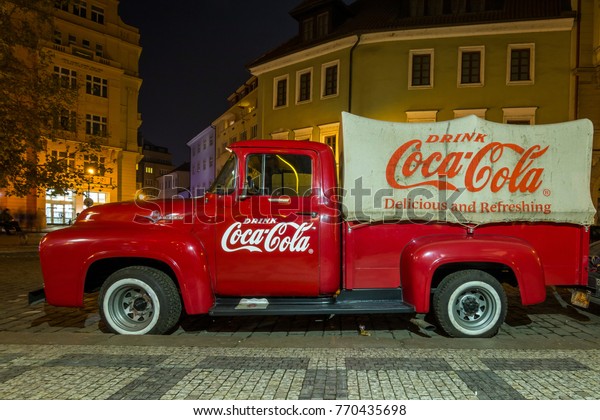 Prague, Czech\
Republic - December 3, 2017: Vintage red car with Coca cola on the\
street of the old city in\
Prague