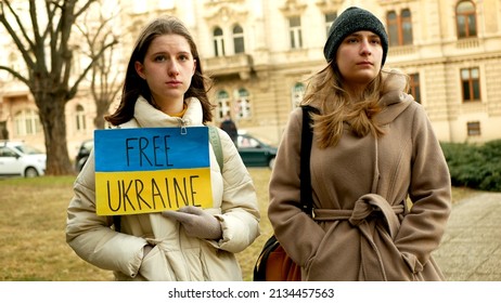 PRAGUE, CZECH REPUBLIC, FEBRUARY 24, 2022: Free Ukraine banner flag Russian military attack demonstration people crowd against war Russia Ukraine protest activist help, girls women crowd