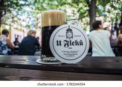 Prague, Czech Republic - July 10 2020: Glass With Dark Beer In U Fleku Beer Garden With Coaster And Logo On A Table.