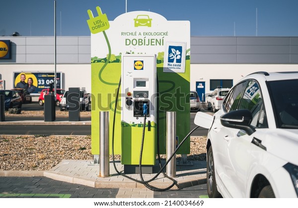 PRAGUE, CZECH\
REPUBLIC - March 26, 2022: Free charging station supermarket Lidl.\
Charging a electric vehicle (NEW SKODA ENYAQ) at a DC charger\
.Electric mobility environment\
friendly
