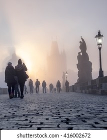 PRAGUE, CZECH REPUBLIC - MARCH 27 2016: Spectators watch the dense fog on Charles Bridge on the bright Easter moring, as the Sun rises over the towers. - Shutterstock ID 416002672