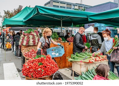 Prague, Czech Republic - May 15, 2021. Traditional Farmers Market In Quarter Of Dejvice. Seller And Customers In Surgical Masks Against Covid19 Coronavirus.Street Vendor With Fresh Vegetable And Herbs