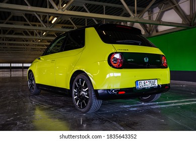 Prague, Czech Republic - October 02, 2020. Yellow Green Electric Honda E Parked In Dark Industrial Parking Spot - Back View