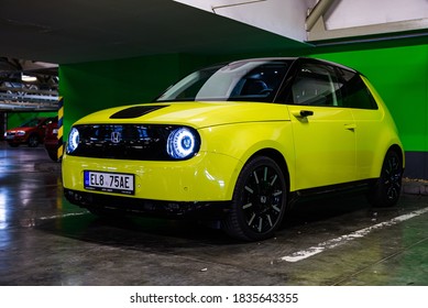 Prague, Czech Republic - October 02, 2020. Yellow Green Electric Honda E Parked In Dark Industrial Parking Spot With Green Key Background - Side View