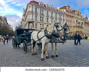 PRAGUE, CZECH REPUBLIC - OCTOBER 10, 2017: Horse drawn carriage servicing tourists at Old Town Square surrounded by iconic gothic architecture, landmarks and old world charm.