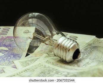 Prague, Czech Republic, October 2021: Energy Price Increase, Light Bulb, Money, Czech Republic, Paper Banknotes, Energy Arrears Debts Photo