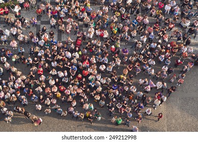PRAGUE, CZECH REPUBLIC - SEPTEMBER 9, 2014: Aerial Top View of Large group of tourists at city central square looking up to Old Town Hall tower.