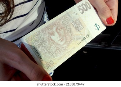 Prague, Czech Republic: The state currency of the Czech Republic - the Czech crown close-up. The girl holds a crown in her hands on the background of the crown. Czech money. European currency. - Shutterstock ID 2133873449