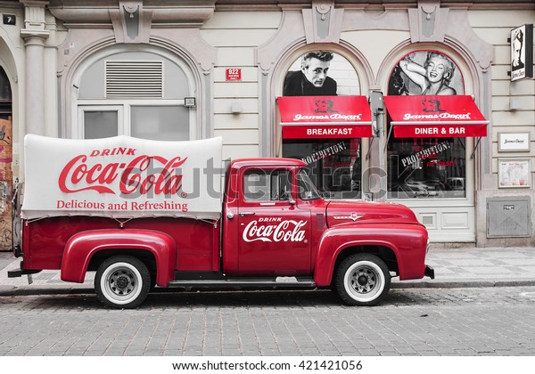 PRAGUE, CZECH REPUBLIC-MAY 15: a red retro\
car Ford F-100 with advertising inscription Coca Cola on board on\
the streets of Prague\'s Old Town May 15,\
2015