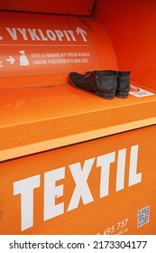 Prague, Czechia - April 15 2021: Detail of orange container for used clothing and shoes used by charitable organisation and local governments