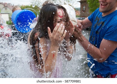 PRAGUE, CZECHIA - FEBRUARY 25, 2017: Girl teenage student splashed by bucket of water during tradition first-year welcome high school ceremony