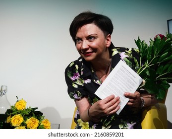 PRAGUE, CZECHIA - Female host is holding her notes while she had received roses flowers during panel discussion, May 23, 2022