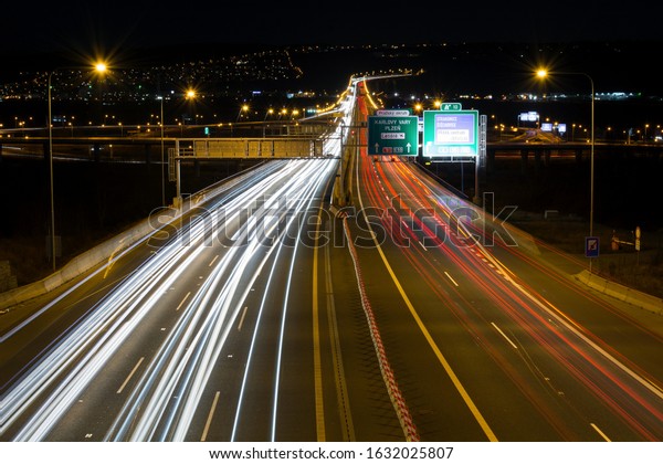 Prague, Czechia - Jun 2019: Light trails on\
highway. Expressway – Prague Ring (Prazsky okruh) is a motorway and\
an outer ring of the city. Speed Traffic – light trails on motorway\
highway at night.