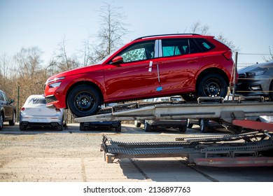 PRAGUE, CZECHIA – MARCH 11, 2022: New Red Škoda Kamiq Crossover - SUV, On Car Carrier Trailer, Car-carrying Trailer, Car Hauler, Auto Transport Trailer, Semi-trailer. Side View.