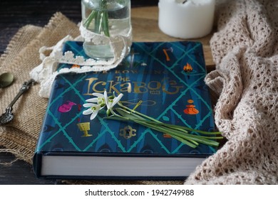 Prague  Czechia - March 24 2021: The Ickabog book by J. K. Rowling lying on a wooden surface along with snowdrops flowers