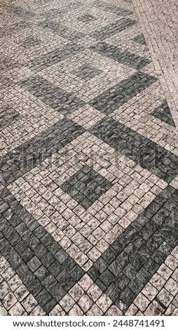 Prague paving stones, tiled path on sidewalks, shadows from trees on a sunny day