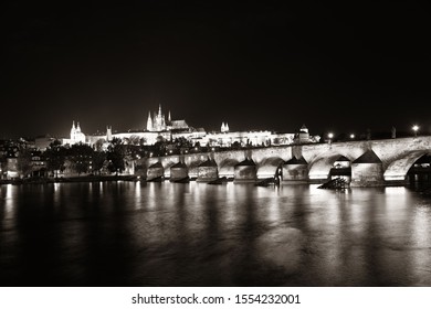 Prague skyline and bridge over river in Czech Republic at night.