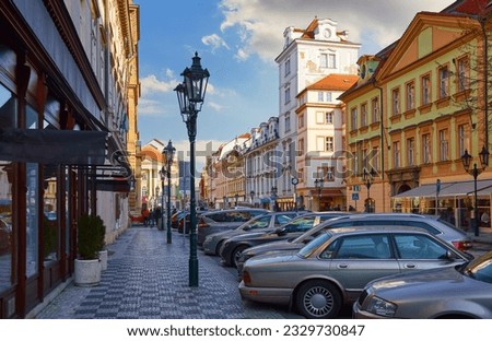 Prague Street with old houses and street lamps. Parked cars along the road. Praha Czech republic. Romantic city view of the old town