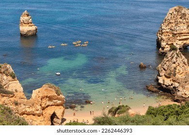 Praia do Camilo (Camilo Beach) in Lagos, Algarve region, Portugal. Beautiful and popular place with nature, calm and flat green waters, natural limestone caves and stone formations.