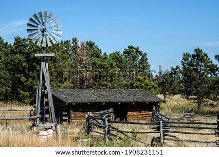 Prairie Log Cabin with a windmill