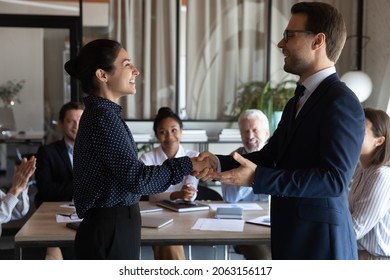 Praise From Boss. Proud Smiling Young Indian Female Corporate Employee Handshaking With Male Ceo Director Leader Receive Recognition On Team Briefing. Overjoyed Ethnic Woman Get Gratitude For Good Job