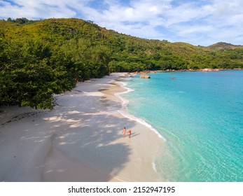 Praslin Seychelles tropical island with withe beaches and palm trees, couple of men and women mid age on vacation at Seychelles visiting the tropical beach of Anse Lazio Praslin Seychelles. 