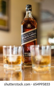 Prathumthani, Thsilsnd - June 4, 2017: Johnnie Walker Black Label bottle with two glasses of whiskey, sealed. The Black Label is a 12 year aged scotch whisky, from the Ayrshire region of Scotland.