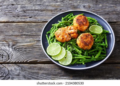 Prawn And Crab Cakes On A Plate With Boiled Green Beans, Lime On A Wood Table, Horizontal View From Above