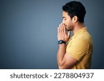 Pray, faith and mockup with a man in studio on a gray background asking god for a miracle or help. Trust, religion and spiritual with a handsome young male christian praying to jesus in belief