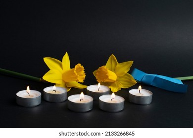 Pray For Ukraine. Burning Candles, Yellow Flowers And Blue Ribbon. Yellow-blue, Colours Of The National Flag Of Ukraine.  Stop War 2022. Copy Space.