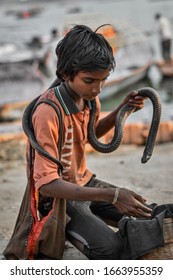 Prayagraj,Uttar Pradesh/India - March 03 2020:
This Boy Belongs To A Poor Family And As A Mean Of Earning He Has A Pet Snake, Who's Poison Has Been Taken Out And Shows It To People To Earn Money.