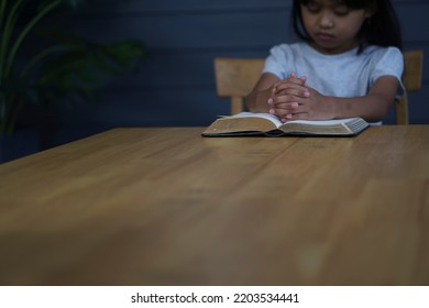 Prayer And Bible Concept. Asian Kid Praying, Hope For Peace And Free From War And Coronavirus, Hand In Hand Together By Child. Little Girl Believes And Faith In Christian Religion At Church.