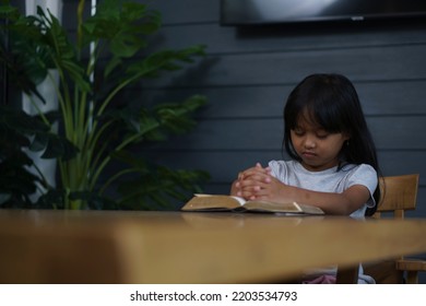 Prayer And Bible Concept. Asian Kid Praying, Hope For Peace And Free From War And Coronavirus, Hand In Hand Together By Child. Little Girl Believes And Faith In Christian Religion At Church.