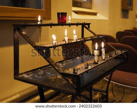 prayer candles lit by worshippers in a Christian church