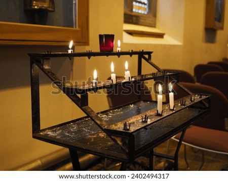 prayer candles lit by worshippers in a Christian church