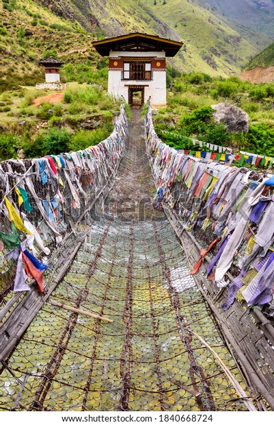 Prayer flags on the iron bridge of Tamchog\
Lhakhang Monastery, Paro River, Bhutan\

