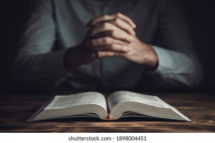 prayer man hand on Bible on dark room 