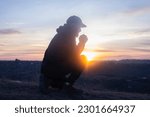 Prayer. Man on his knees praying. On the background of the sunset sky. Kneeling Prayer to God. Worship and praise.