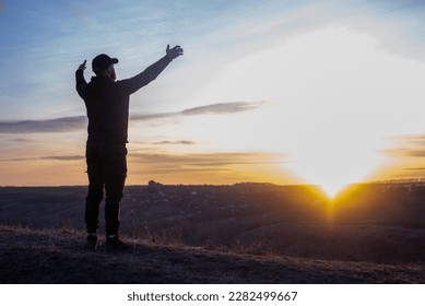 Prayer. Man on his knees praying. Against the background of the sky and sunset. Forgiveness of sins and repentance. Easter - Shutterstock ID 2282499667