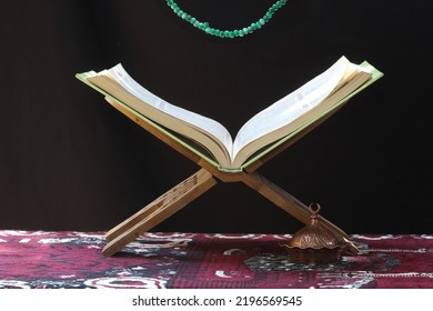 Prayer Rug, Rosary And Holy Quran And Lectern On Dark Background