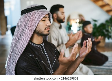 Prayer With A Thankful Heart. Shot Of A Group Of Muslim Male Family Members Praying Together.