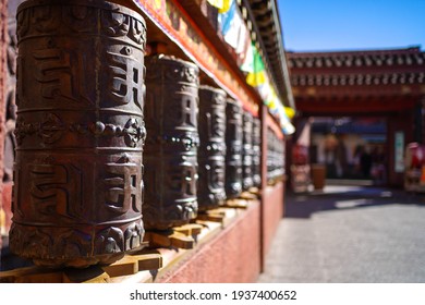 Prayer wheels (Mani wheels) in a tibetan culture temple in yunnan china. Translation : writings on the wheels are the Sanskrit mantra "Om Mani Padme Hum" written in Tibetan