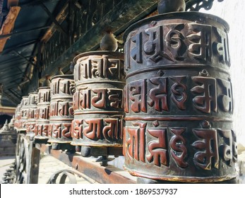 Prayer wheels or Tibetan brass praying wheel at Swayambunath temple in Kathmandu. The script written on it is the "Om mani padme hum"mantra that roughly translate to "jewel lotus flower enlightenment"