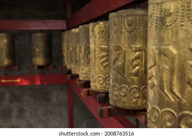 Prayer wheels at a Tibetan Buddhist temple in Dharamsala, inscribed with the mantra 'Om mani padme hum'. Rough translation: "Praise to the jewel in the lotus"