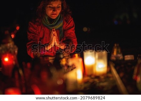 prayer woman. Candles in the cemetery. 1st November. Feast of All Saints. Hallowmas. All Souls' Day.