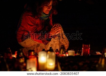 prayer woman. Candles in the cemetery. 1st November. Feast of All Saints. Hallowmas. All Souls' Day.