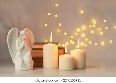 praying angel and candles on table, abstract light background. Christmas or Easter concept. Religious church holiday. symbol of faith in God, Christianity Feast