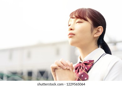 Praying Asian School Girl.