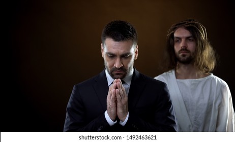 Praying Businessman Joining Hands, Messiah Standing Behind, Spiritual Support