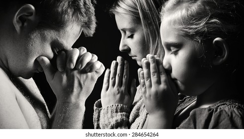 Praying family. Man, woman and child. MANY OTHER PHOTOS FROM THIS SERIES IN MY PORTFOLIO.